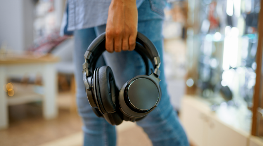Headphones being held by a person in a studio setting