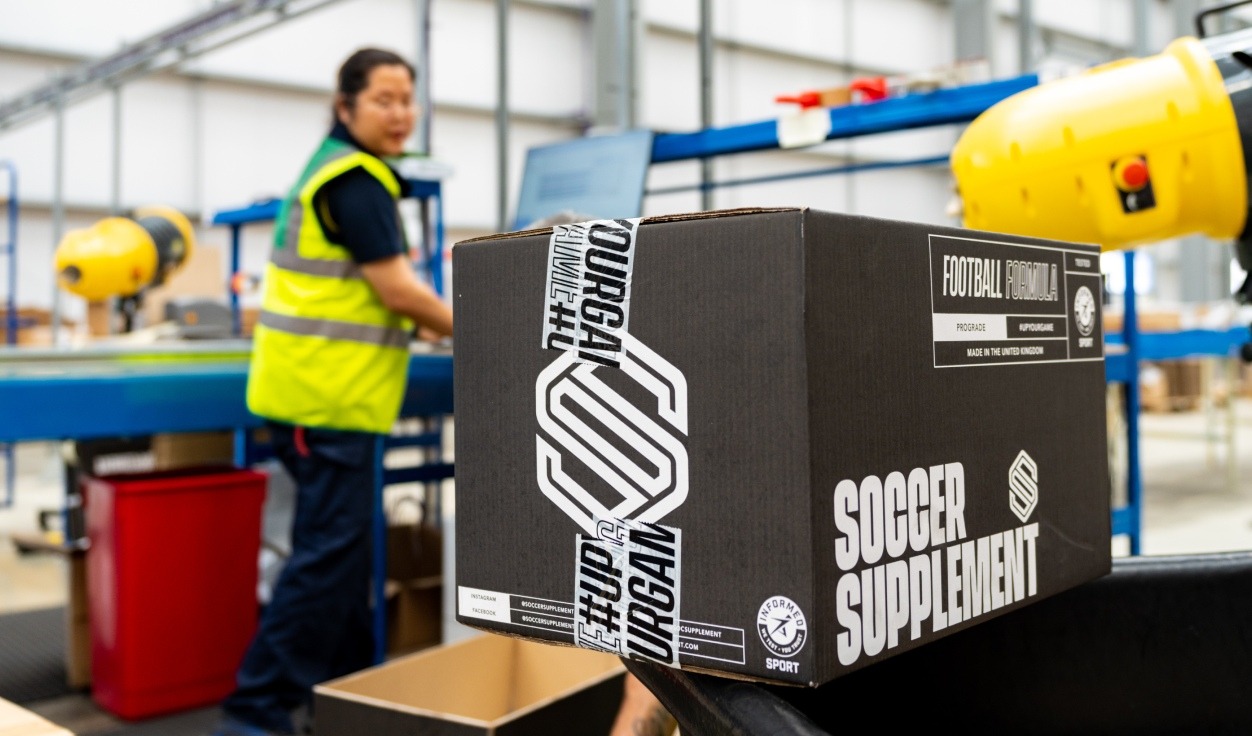 Warehouse worker and soccer supplement box
