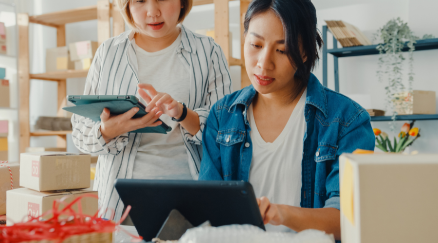 Two women working on tablets, running their business