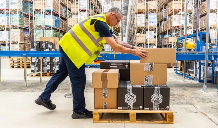 warehouse packer stacking boxes